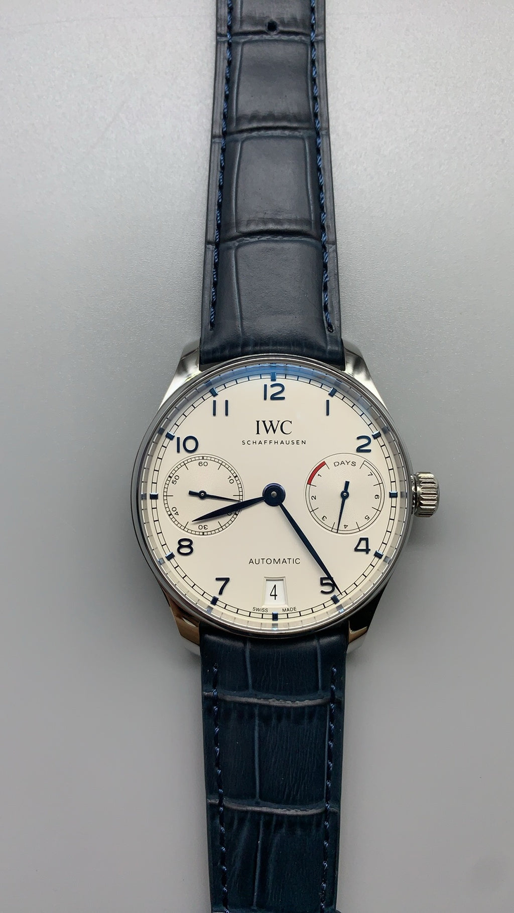 IWC Portugieser Automatic IW500705 | 42.3MM | ตัวเรือนสเตนเลสสตีล | หน้าปัดสีขาว | เข็มสีน้ำเงิน | สายหนังจระเข้สีน้ำเงิน | กลไกอัตโนมัติ Cal.52010