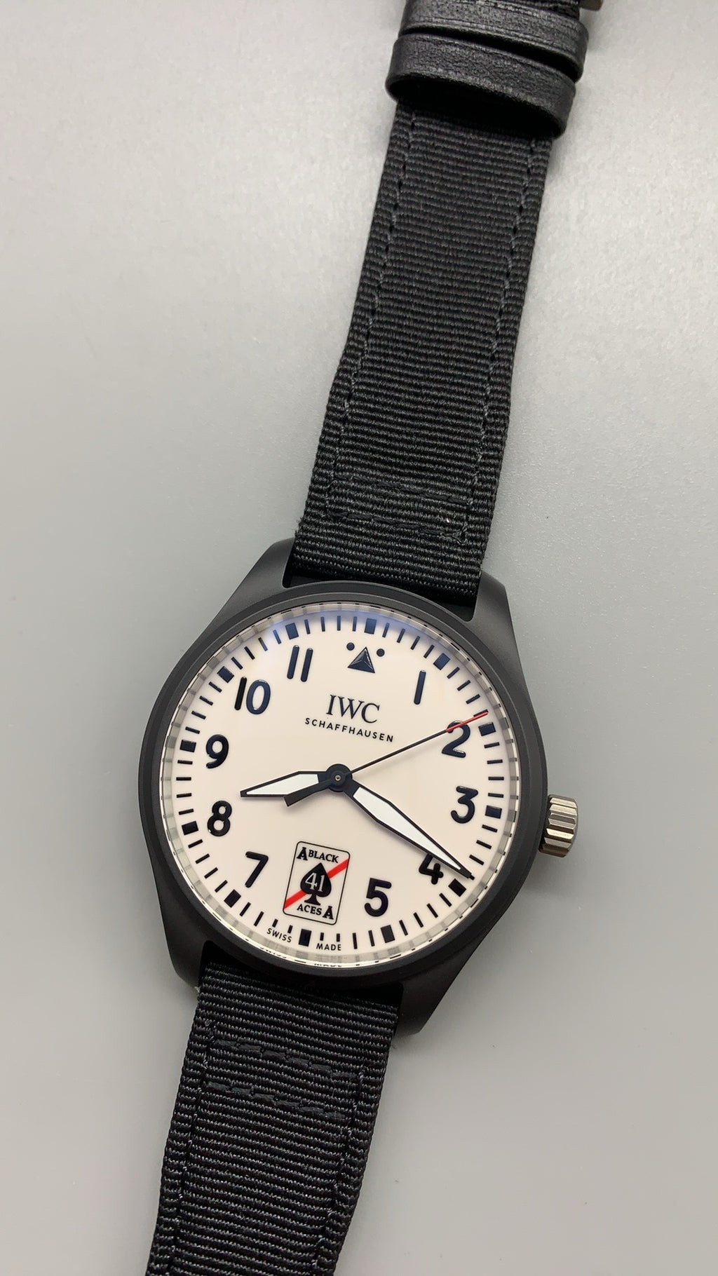 IWC Pilot's Watch Automatic Black Aces | 41MM | ตัวเรือนเซรามิกสีดำ | หน้าปัดสีขาวพิมพ์โลโก้ Black Aces | สายผ้า NATO สีดำ | กลไกอัตโนมัติ Cal.32100